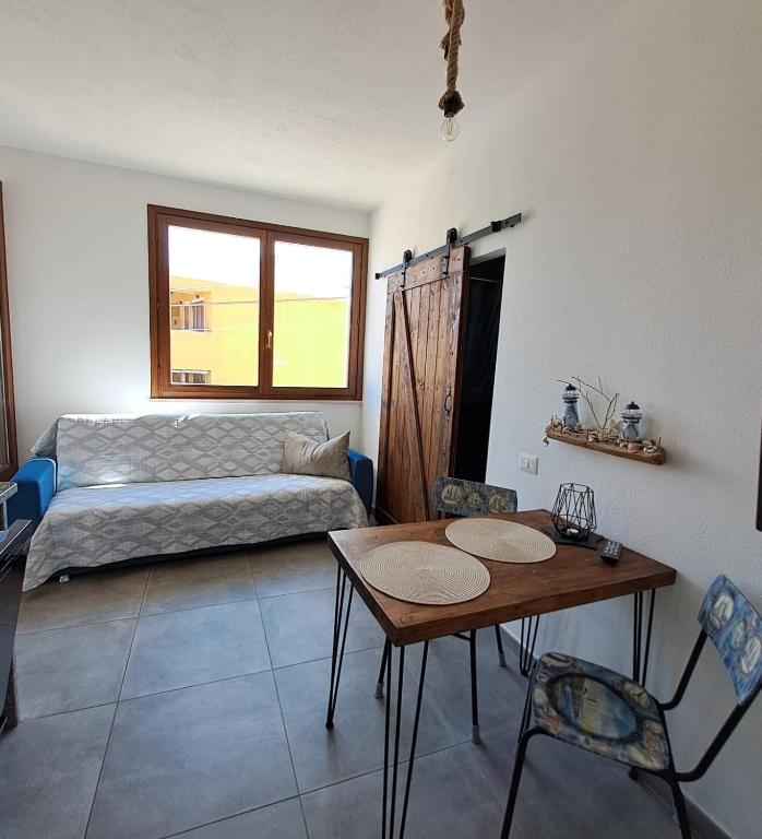 a living room with a bed and a table and chairs at Il Faro La Ciaccia in Codaruina