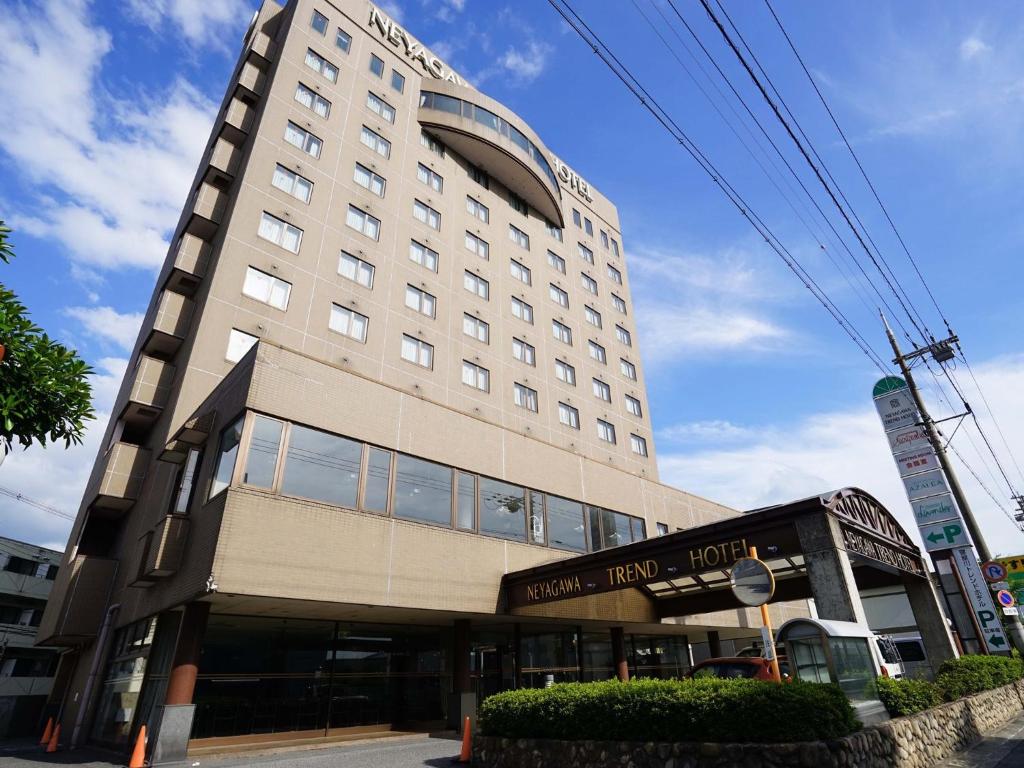 a large hotel building on the corner of a street at Neyagawa Trend Hotel in Neyagawa