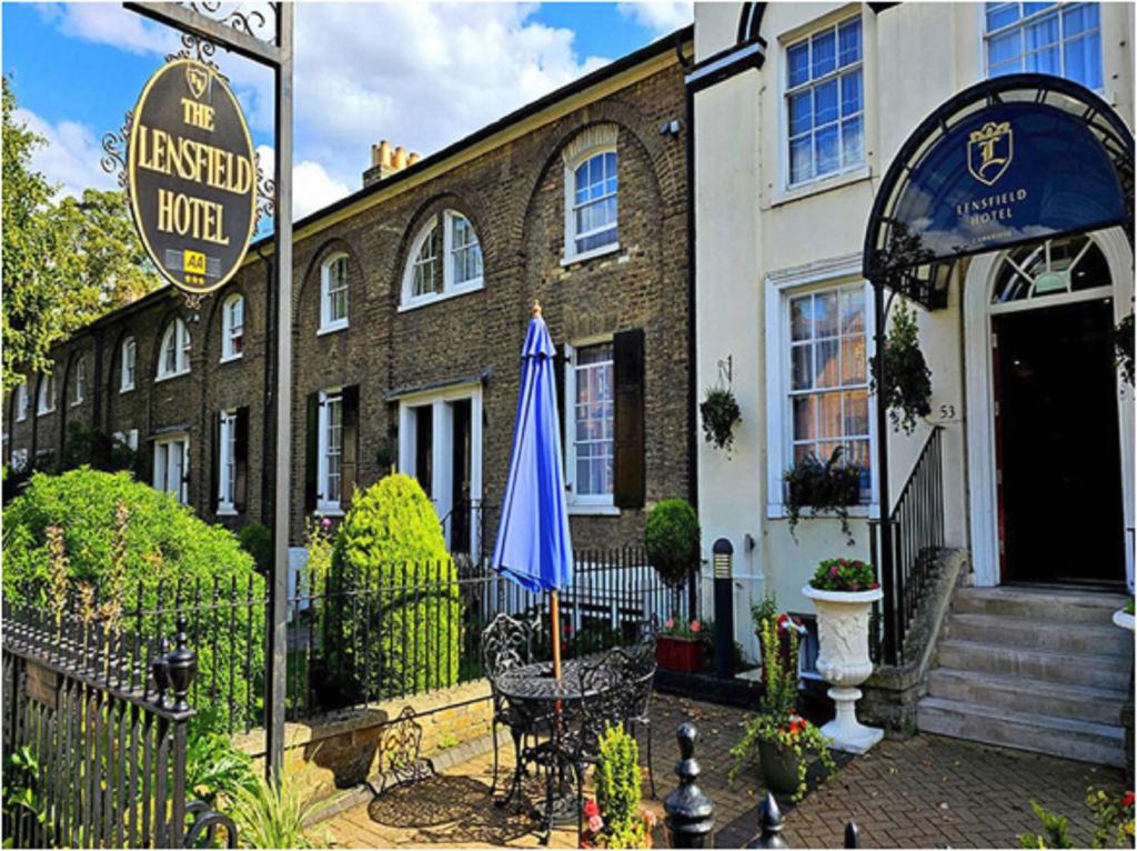 un hotel con una sombrilla azul frente a un edificio en Lensfield Hotel, en Cambridge