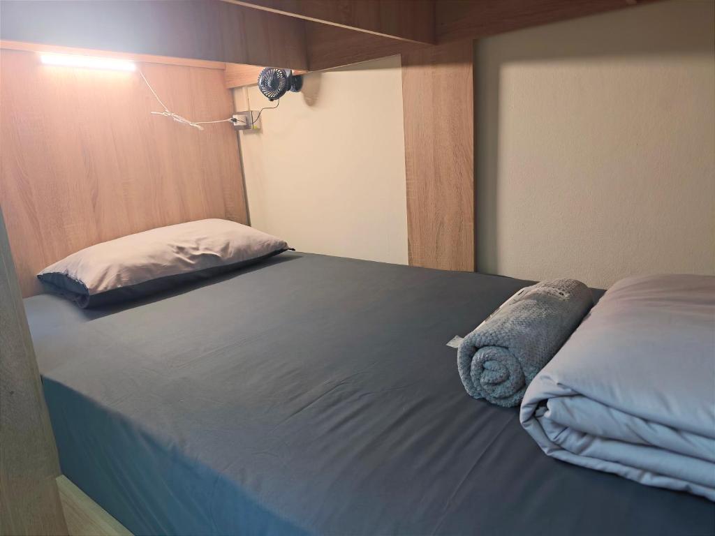 a bedroom with a blue bed with a pillow at Panda Lodge Home Stay in Bangkok