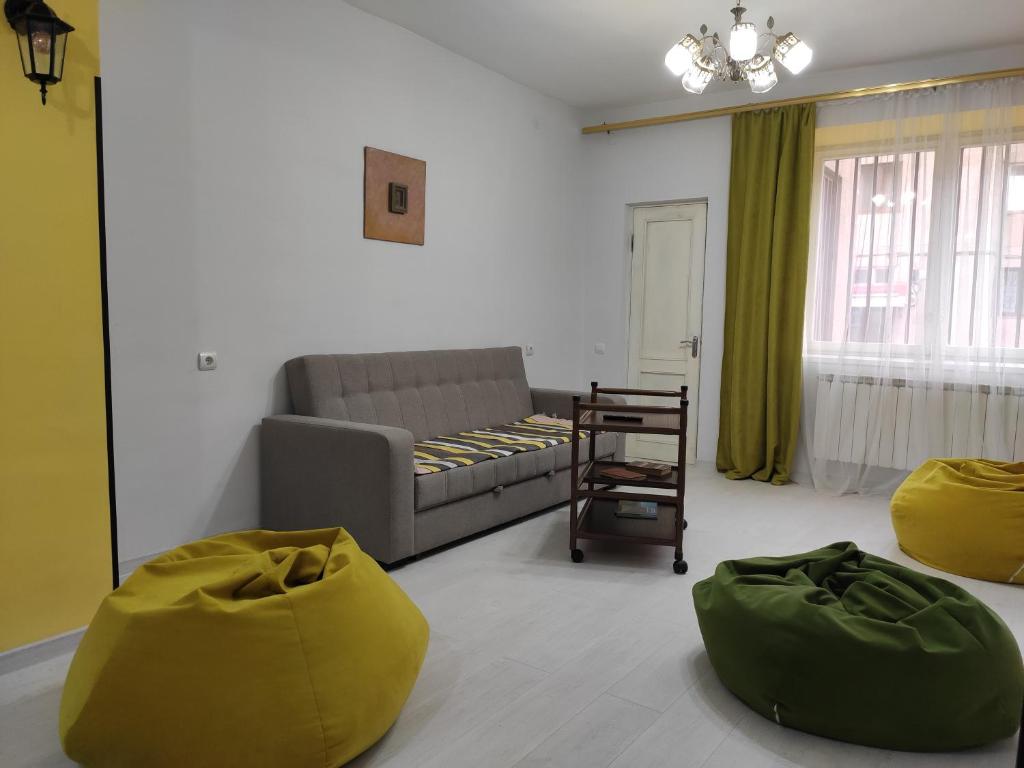 a living room with a couch and two green ottoman at Ners Guest House in Gyumri