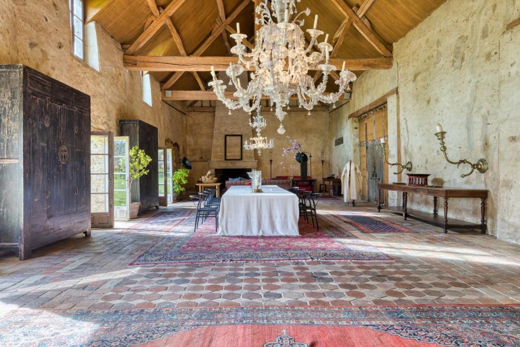 Habitación grande con mesa y lámpara de araña. en Le Montoir en Faverolles