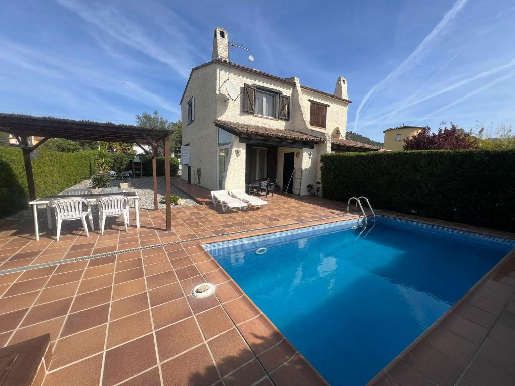 a villa with a swimming pool in front of a house at Alemanya 9 privat pool in L'Estartit