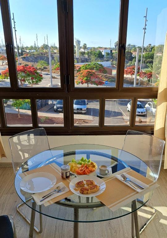 a glass table with a plate of food on it at Casa Susanna Apartment Costa del Silencio in Costa Del Silencio