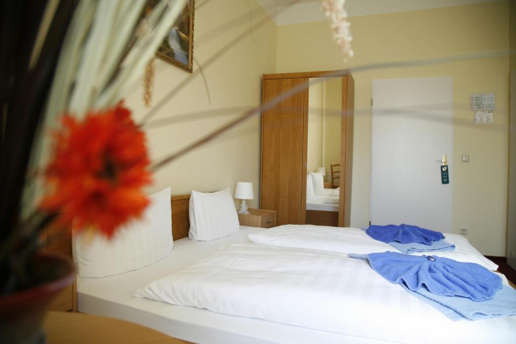 a bedroom with a bed with white sheets and a mirror at Hotel AI Königshof in Berlin