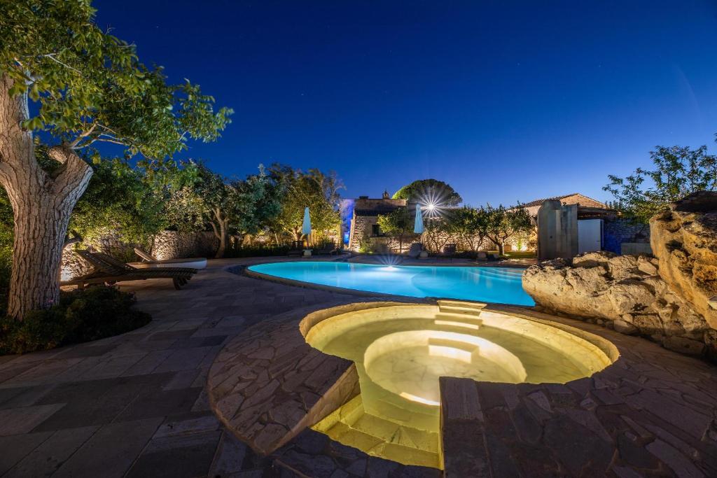 una piscina en un patio por la noche en Masseria Blanca Lapis, en Martano