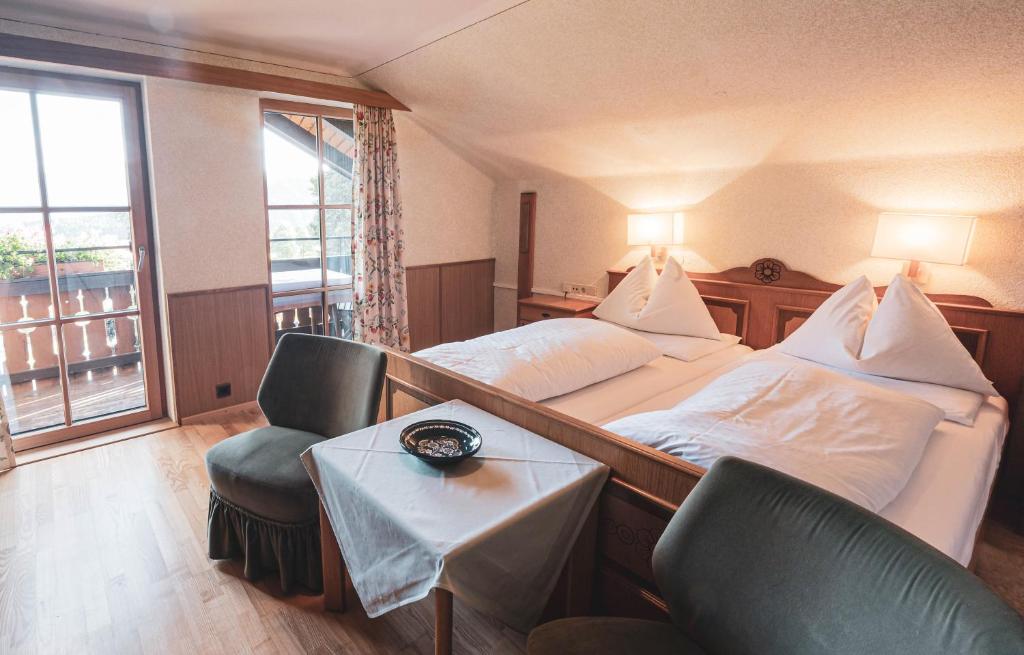 a hotel room with a bed and a table and chairs at B & B Feistererhof in Ramsau am Dachstein