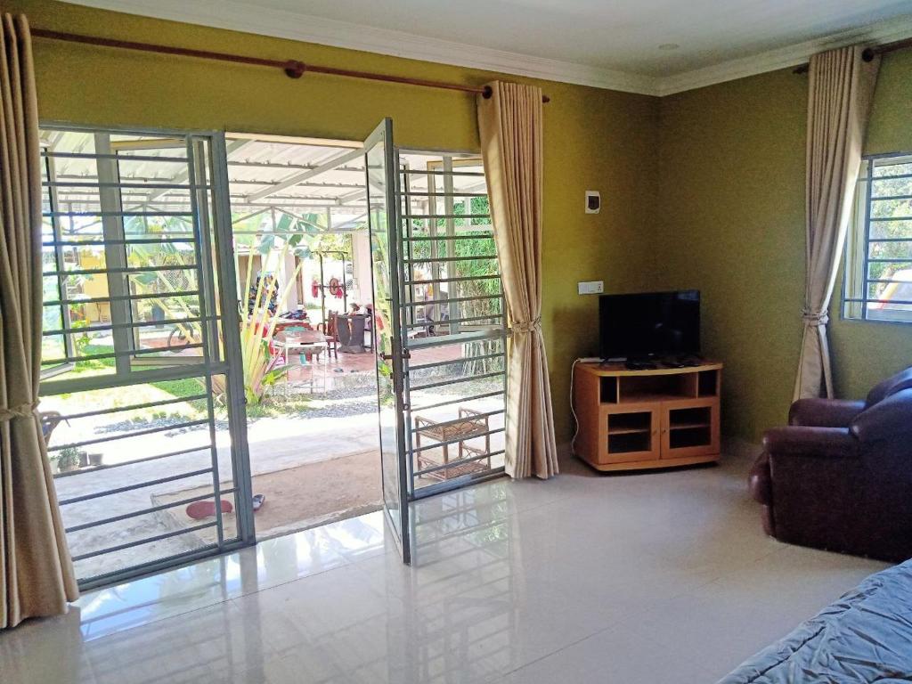 a living room with a sliding glass door to a patio at 2sisters garden Bungalow in Kampot