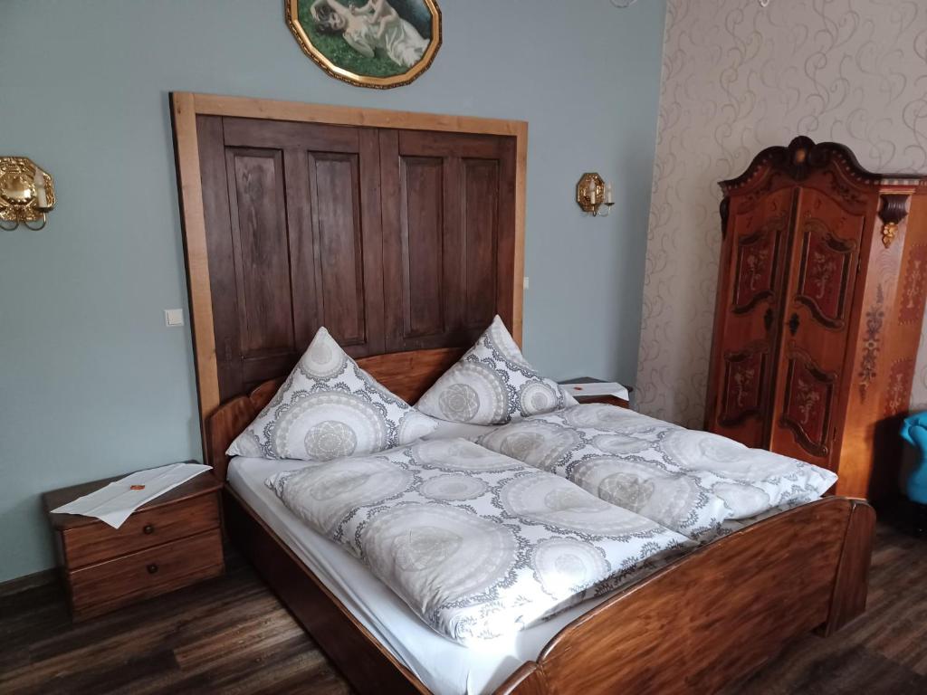 Una cama con sábanas blancas y almohadas en un dormitorio en Gästehaus Frevel, en Münstermaifeld