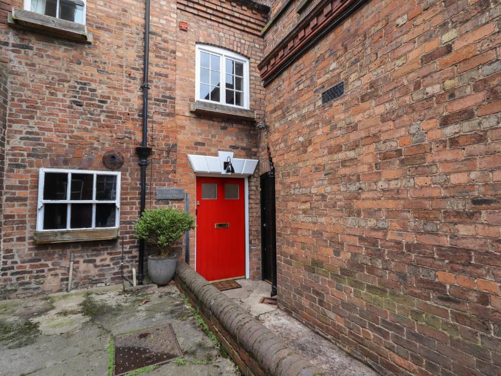 a red door in the side of a brick building at The Old Sorting Office in Hawarden