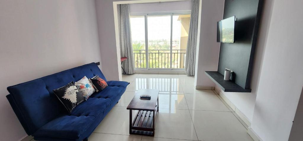 a living room with a blue couch and a table at 508 SD Zanita Heights in Vasco Da Gama