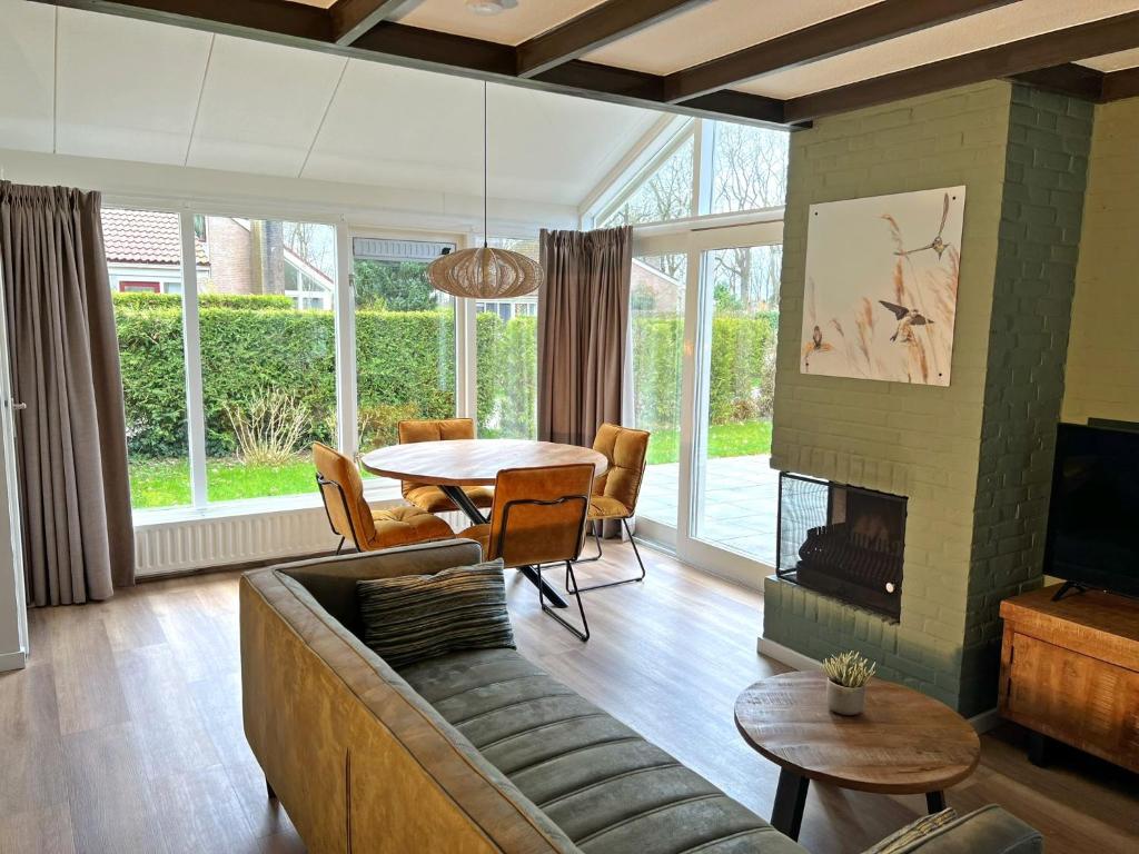 ein Wohnzimmer mit einem Sofa und einem Tisch in der Unterkunft Vakantiewoning de Oeverzwaluw in hartje Drenthe in Zwiggelte