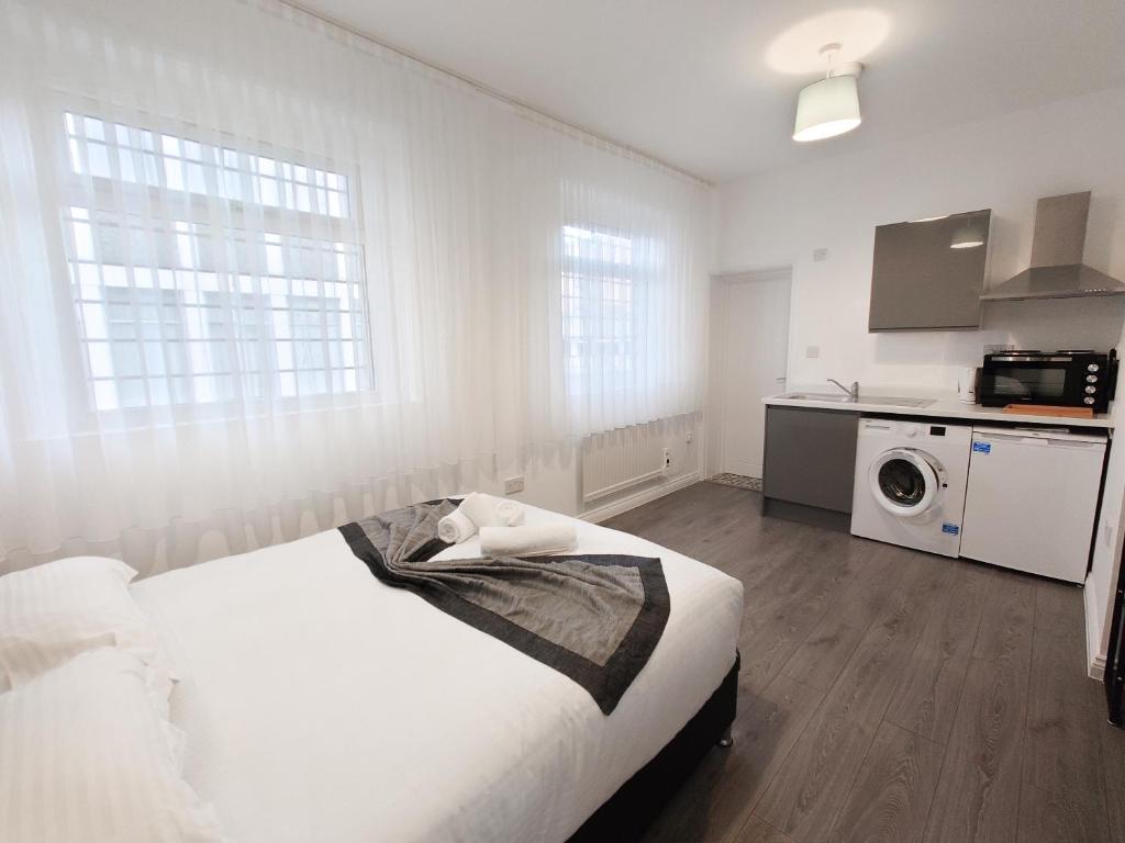 a white room with a bed and a kitchen at Centra Station in London