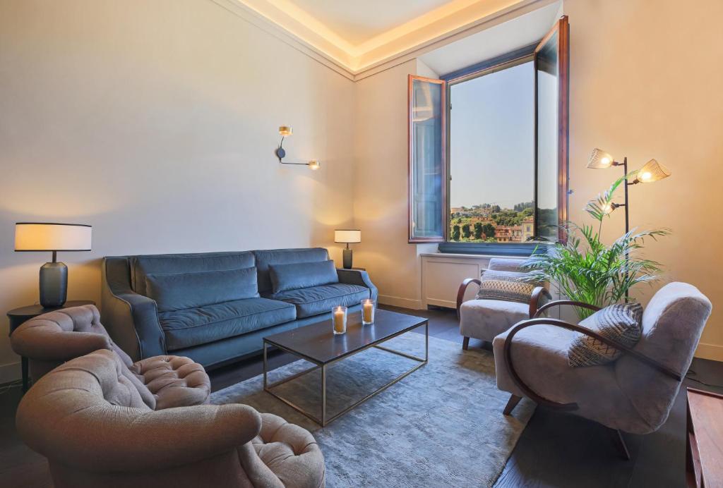 a living room with a couch and chairs and a window at Apartments Florence- Palazzo Benci with river view · Palazzo Benci with river view in Florence