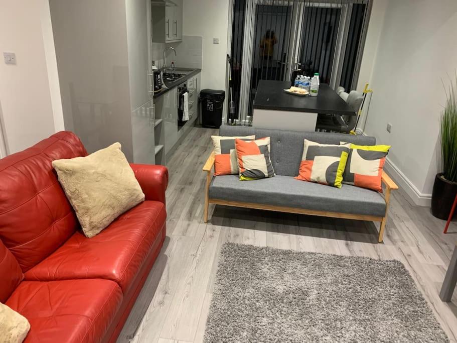 sala de estar con sofá rojo y almohadas en Beautiful 5Bedroom Hse-Contractor/Family/Corporate en Kent