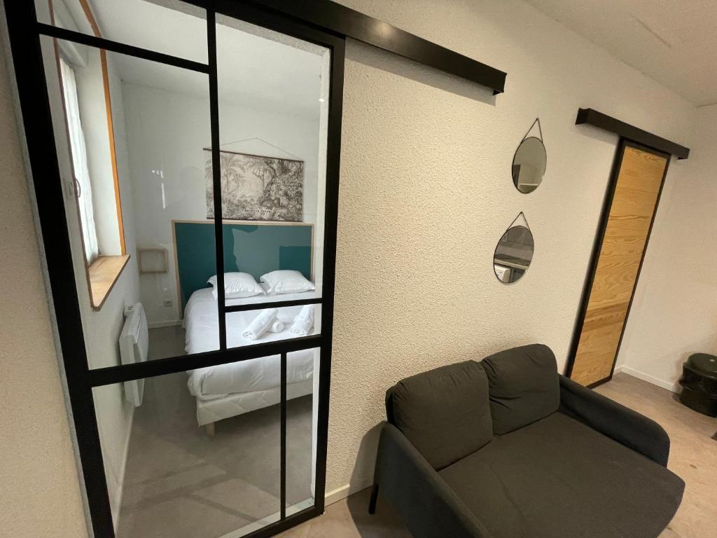 a living room with a couch and a bedroom at APPARTEMENT HYPER CENTRE numéro 101 in Roanne