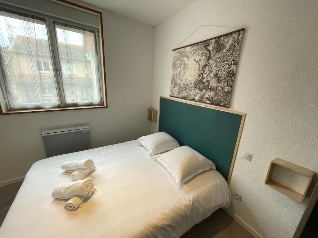 a bedroom with a bed with two towels on it at APPARTEMENT HYPER CENTRE numéro 101 in Roanne
