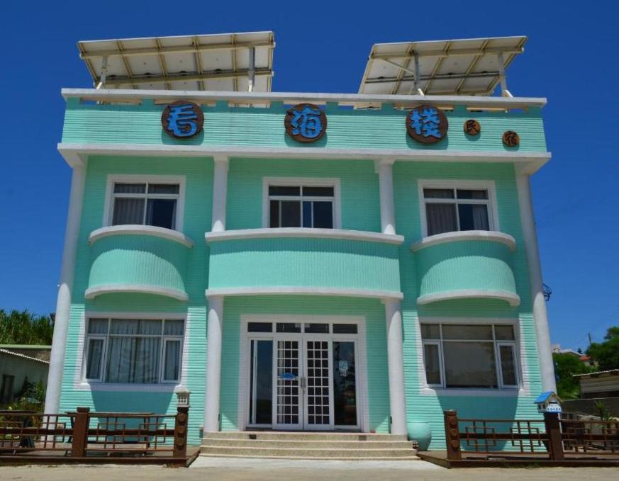 a blue building with clocks on the top of it at Sea Front Homestay in Magong