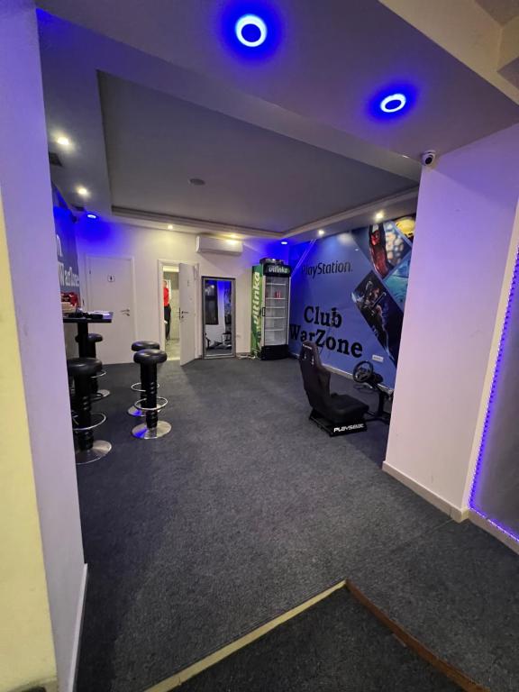 Zimmer mit einem Fitnessraum mit blauen Lichtern und Stühlen in der Unterkunft Club PlayStation “WarZone” Banjaluka in Banja Luka