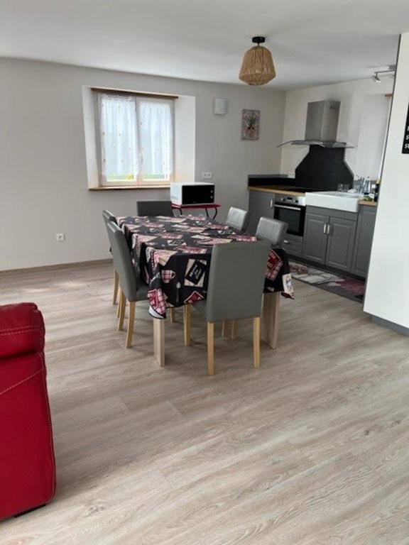 une salle à manger avec une table et des chaises dans une cuisine dans l'établissement Gites aux deux Hameaux 2, à Saint-Pierre-Bois