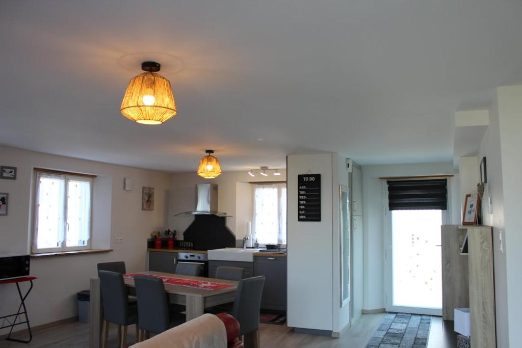 une cuisine et une salle à manger avec une table et des chaises dans l'établissement Gites aux deux Hameaux 2, à Saint-Pierre-Bois