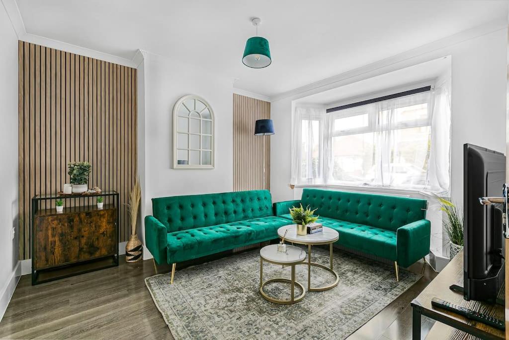 sala de estar con sofá verde y TV en Luxury Large House With Games Room Sleeps Up to 12 en Feltham