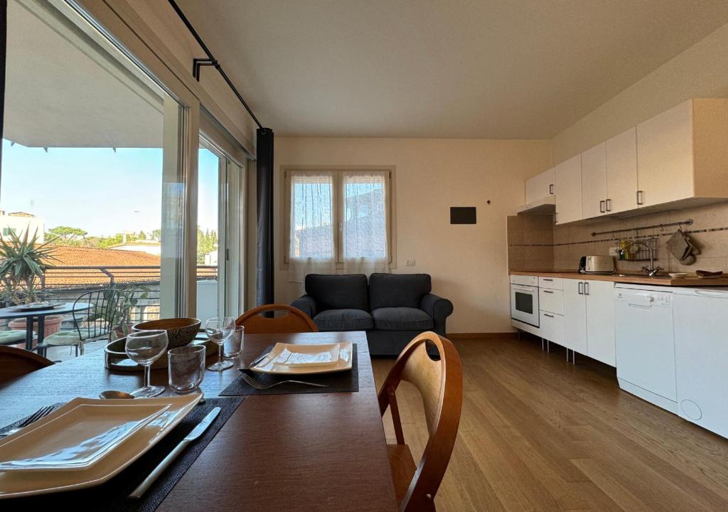eine Küche und ein Wohnzimmer mit einem Tisch und einem Sofa in der Unterkunft Maison Linda - Ponte Milvio Apartment in Rom