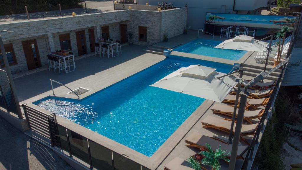 Una vista aérea de una piscina con sombrillas. en Luxury Apartment & Rooms, en Ljubuški