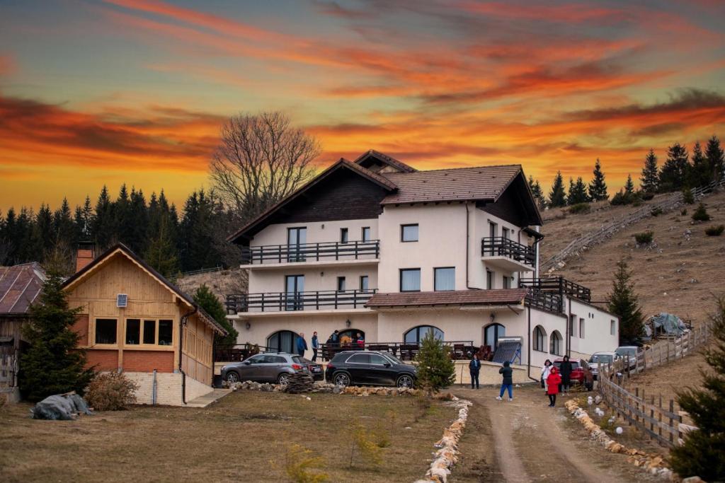 uma casa numa colina com um pôr-do-sol ao fundo em La Rocca em Fundata