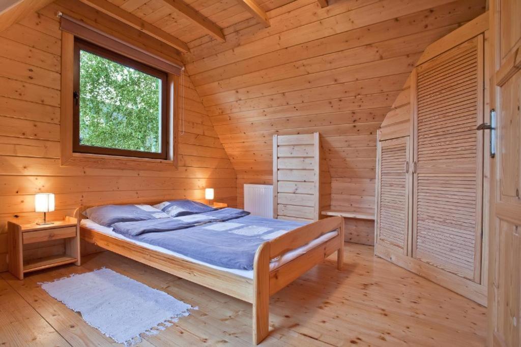 a bedroom with a bed in a wooden cabin at Domek w Krynicy z sauną in Krynica Zdrój