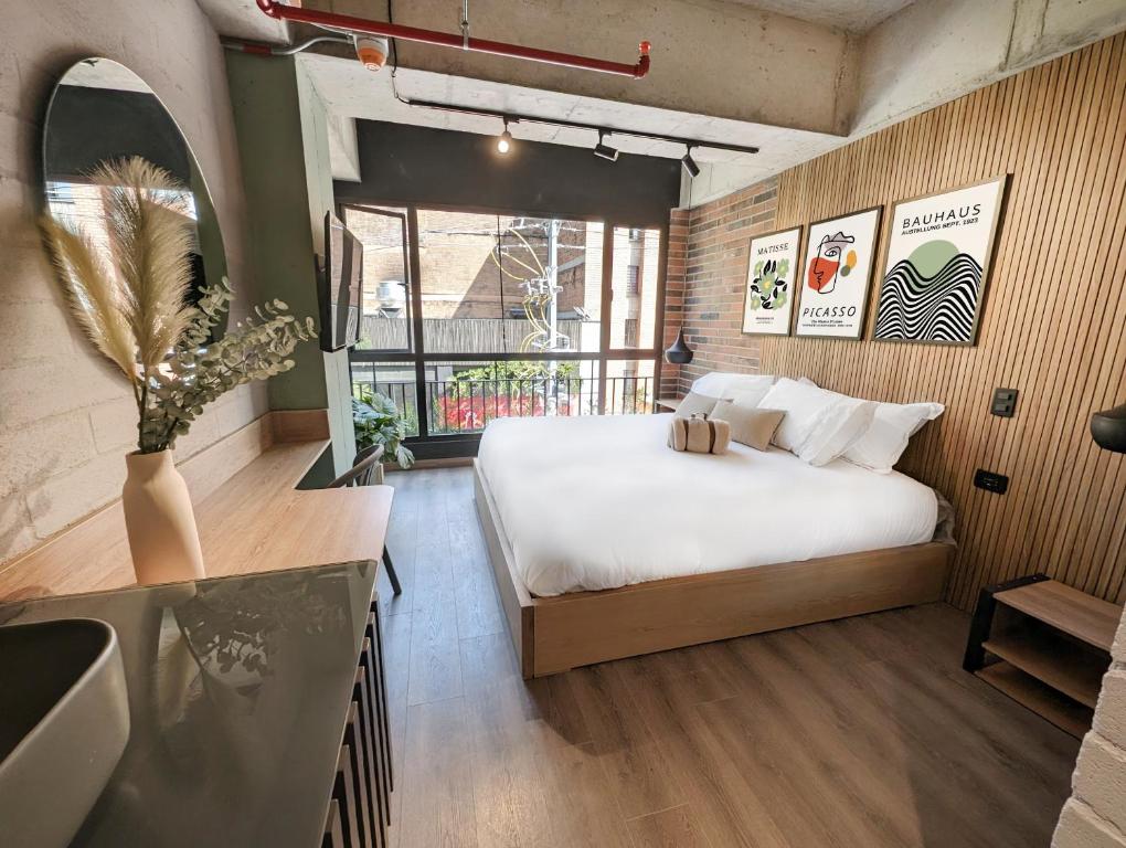 Urbit Social Lofts في ميديلين: غرفة نوم بسرير ومطبخ مع حوض