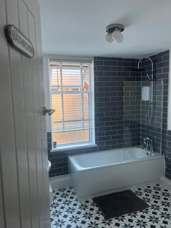 a bathroom with a tub and a window at No. 73 in Liverpool