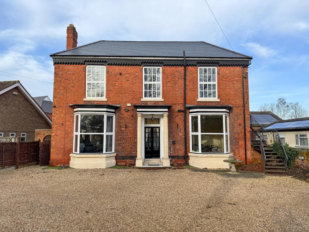 a red brick house with white windows on a street at Beldon House in Brigg