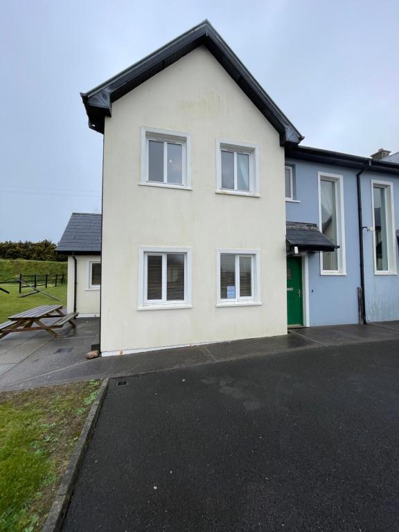 a white house with a black roof at Glor Na Farraige 15 in Knights Town