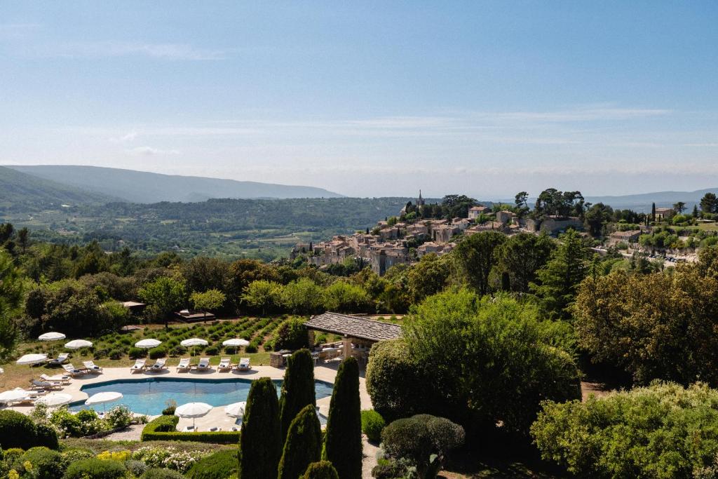 - une vue sur un complexe avec une piscine et une ville dans l'établissement Capelongue, a Beaumier hotel & Spa, à Bonnieux