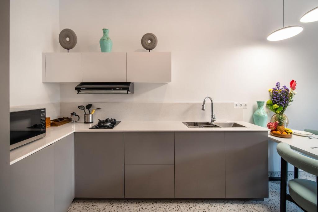 a kitchen with white cabinets and a sink at Sunny Village Berawa in Canggu