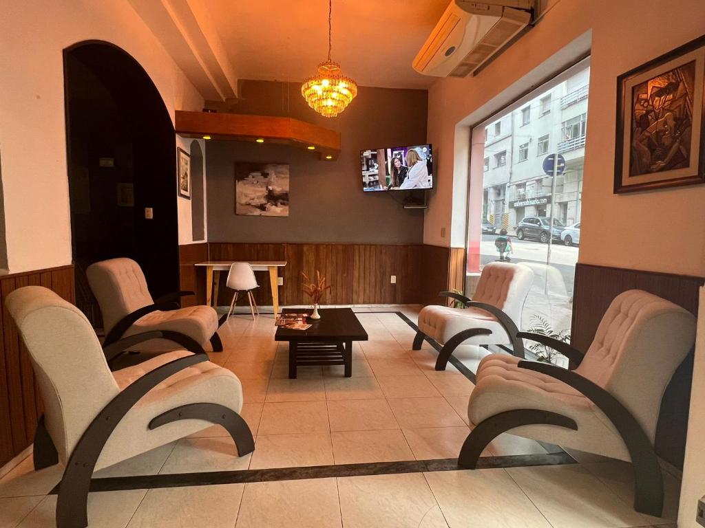 une salle d'attente avec des chaises et une télévision dans l'établissement HOTEL MEDITERRANEO, à Montevideo