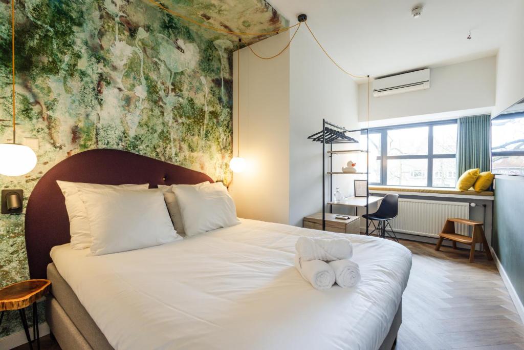 a bedroom with a bed with two towels on it at Badhuis Hotel in Utrecht