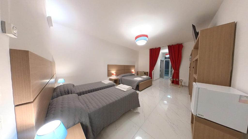 a hotel room with two beds and a television at San Cataldo Hotel in Faggiano