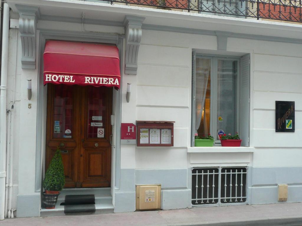 ヴィシーにあるHôtel Rivieraのホテルの入り口とドアのある建物