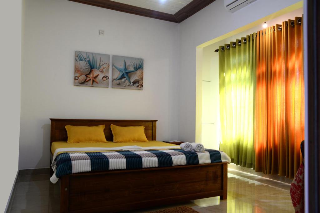 a bedroom with a bed with yellow pillows at Green Bird Villas in Kandy