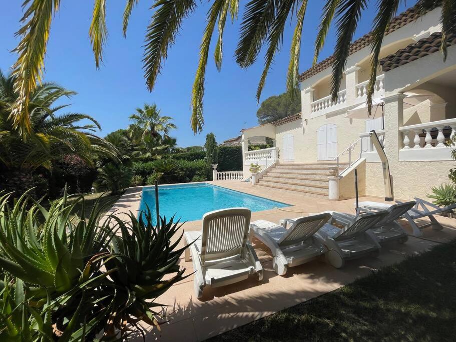 a house with two chairs and a swimming pool at Maison cosy en bordure du golf. in Saint-Raphaël