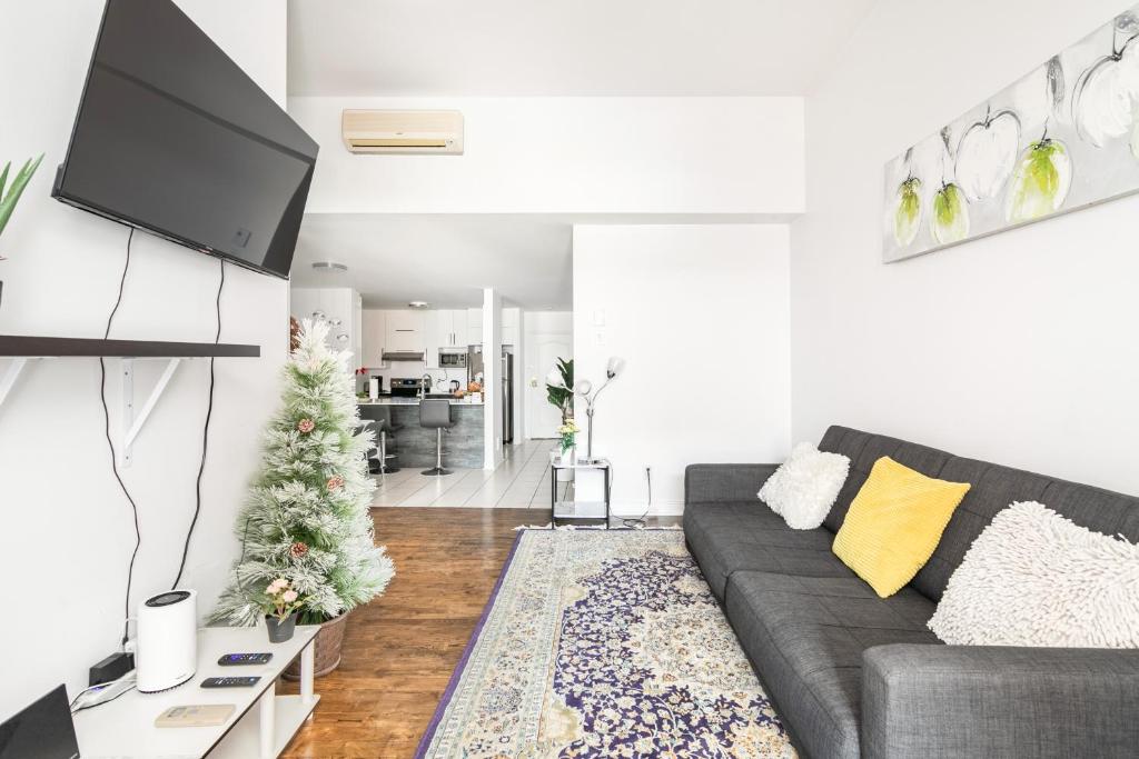 sala de estar con sofá y árbol de Navidad en Luxueux condo au cœur de Québec!, en Quebec