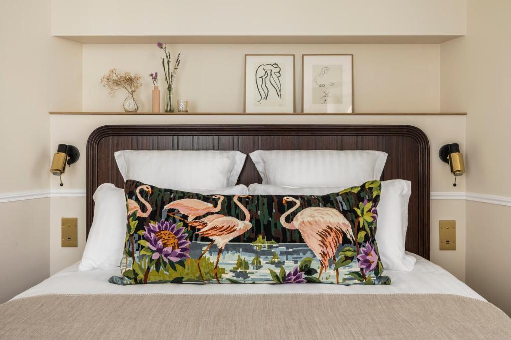 Una cama con una almohada con flamencos. en Hôtel Chamar, en París