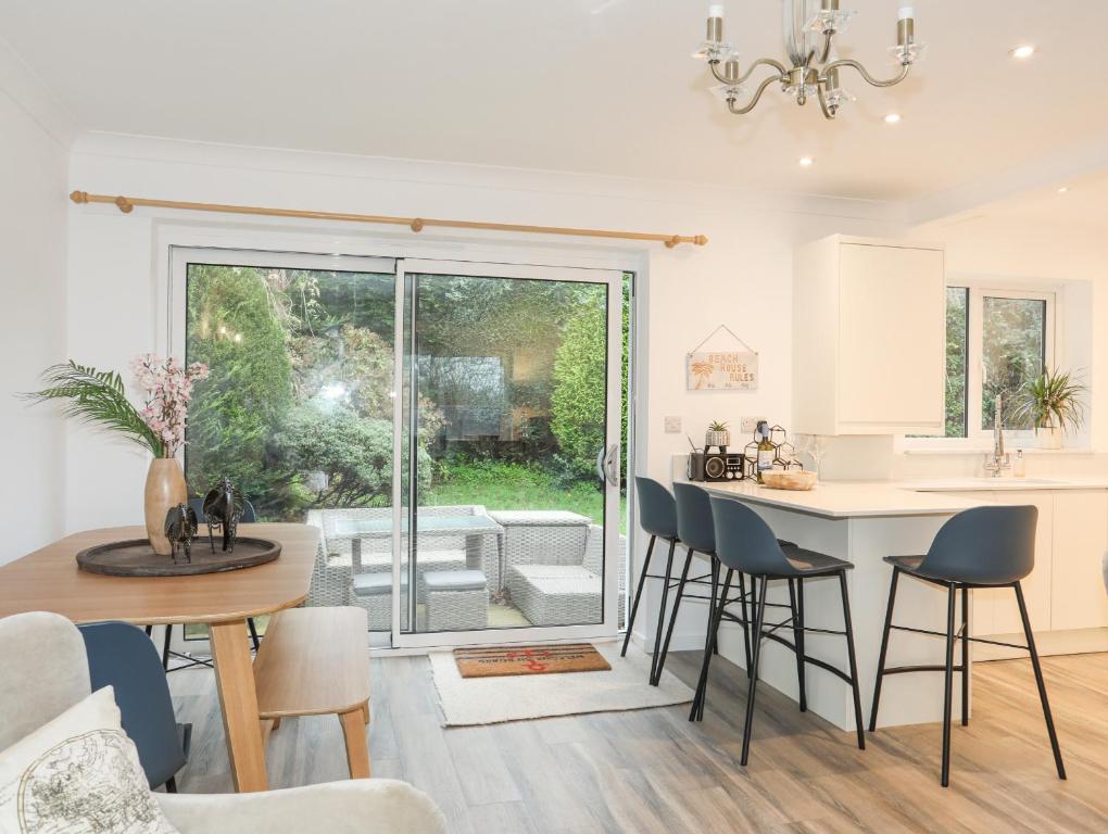 a kitchen and living room with a table and chairs at 15 Maes Awel in Pwllheli