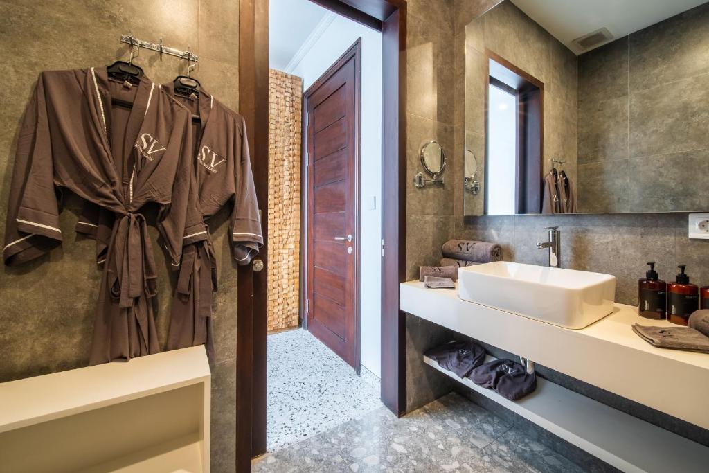 a bathroom with a sink and a mirror at Sunny Village Berawa in Canggu