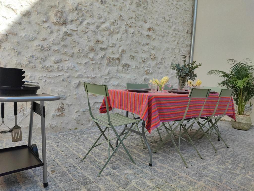 une table avec des chaises vertes et un tissu de table rouge dans l'établissement Maison rénovée-moderne avec cour à 2 pas du centre, à Orléans