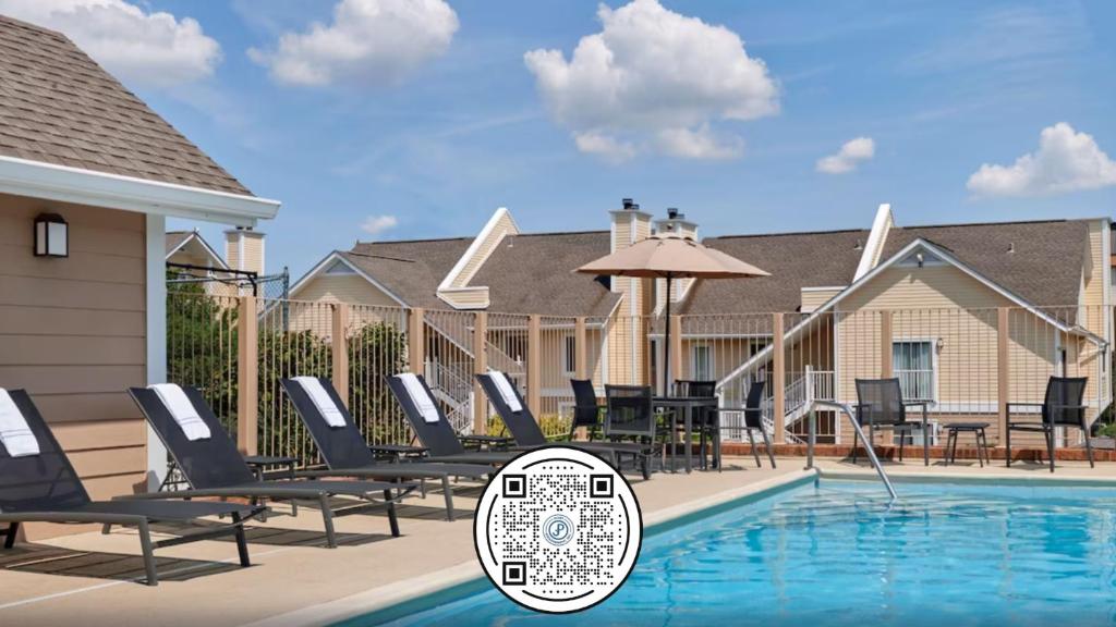 a swimming pool with lounge chairs and an umbrella at Sonesta ES Suites Cleveland Airport in Middleburg Heights