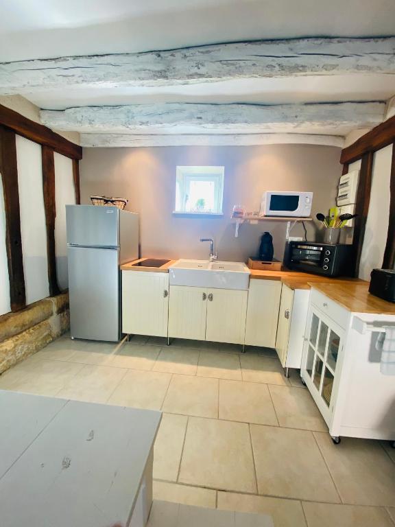 a kitchen with a white refrigerator and a sink at Gîte de la Grange in Colombiers