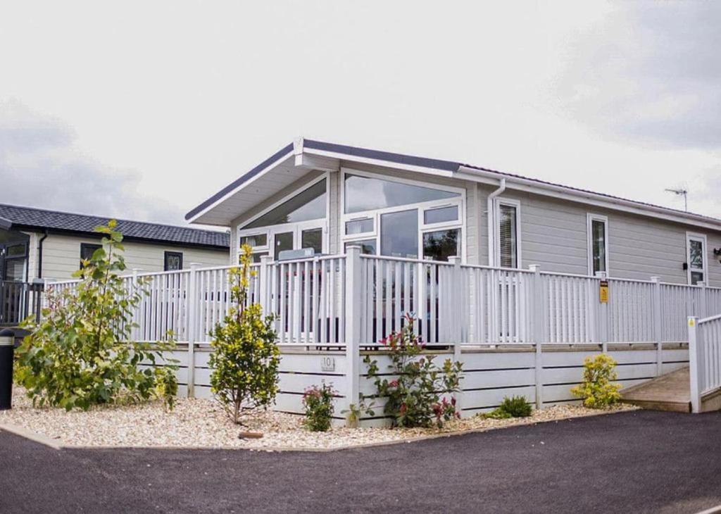 a house with a white fence in front of it at Remarkable 3-Bed Lodge in Honiton in Honiton
